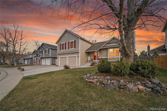 12028 W Aqueduct Dr, Littleton, CO 80127 - view of front of house featuring a garage, a yard, fence, and concrete driveway