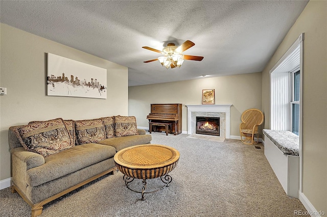 12028 W Aqueduct Dr, Littleton, CO 80127 - carpeted living area featuring a fireplace, a textured ceiling, baseboards, and ceiling fan