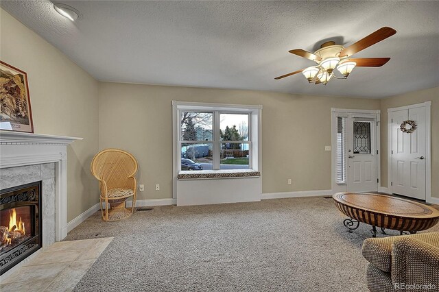 12028 W Aqueduct Dr, Littleton, CO 80127 - carpeted living area featuring baseboards, a high end fireplace, a textured ceiling, and a ceiling fan