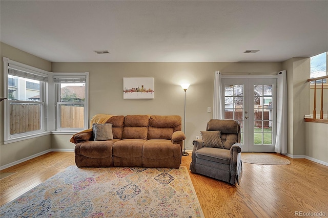 12028 W Aqueduct Dr, Littleton, CO 80127 - living area featuring visible vents, french doors, baseboards, and light wood-style floors