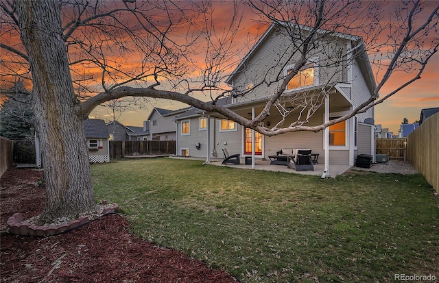 12028 W Aqueduct Dr, Littleton, CO 80127 - back of house with a patio area, a fenced backyard, a lawn, and an outbuilding