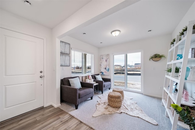 living area featuring light wood-style flooring and baseboards