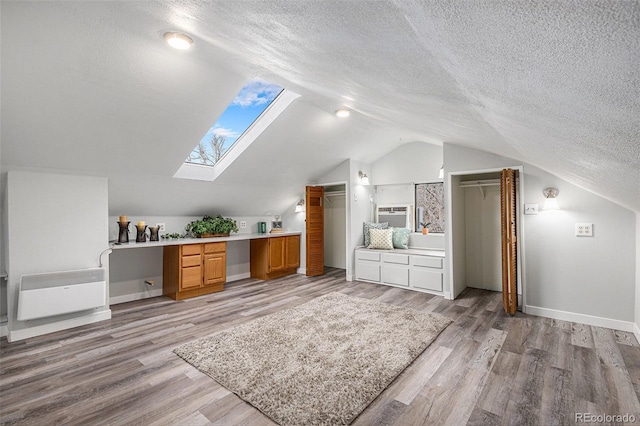 225 N Cedar St, Colorado Springs, CO 80903 - bonus room featuring light wood-type flooring, a textured ceiling, built in study area, baseboards, and lofted ceiling with skylight