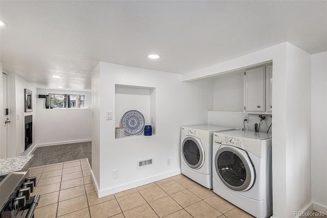 225 N Cedar St, Colorado Springs, CO 80903 - laundry area featuring visible vents, light tile patterned floors, cabinet space, and washer and clothes dryer