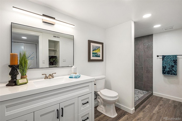 225 N Cedar St, Colorado Springs, CO 80903 - bathroom with vanity, toilet, visible vents, a tile shower, and wood finished floors