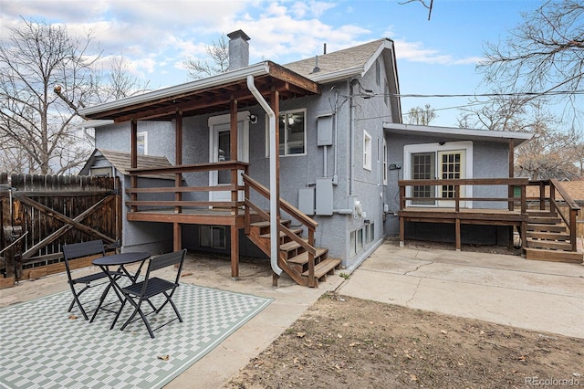 225 N Cedar St, Colorado Springs, CO 80903 - rear view of house featuring a patio area, stucco siding, fence, and a chimney