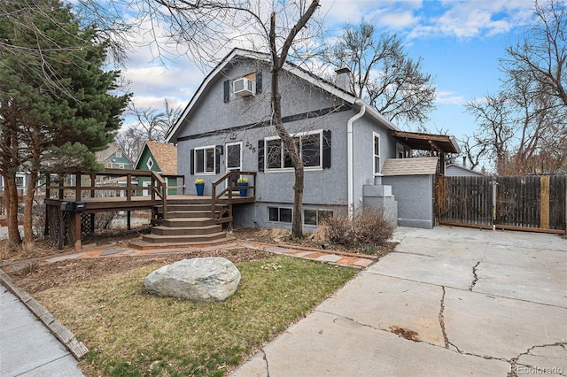 225 N Cedar St, Colorado Springs, CO 80903 - bungalow-style home featuring a wooden deck, stucco siding, a gate, a chimney, and concrete driveway