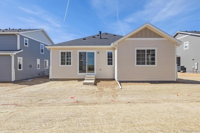 back of property with entry steps, central air condition unit, and board and batten siding