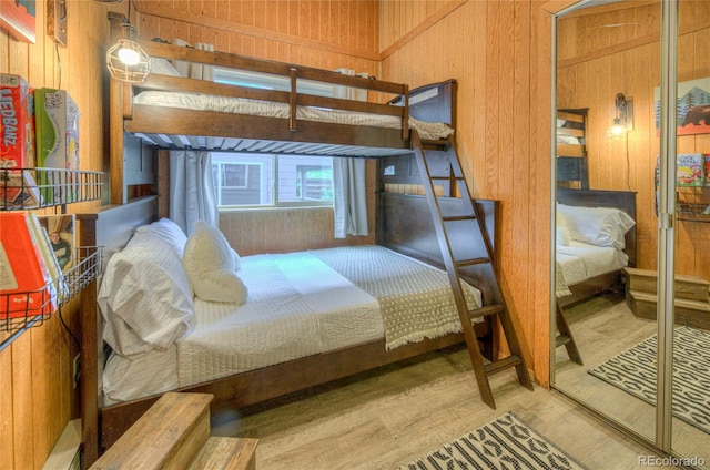 bedroom with wooden walls and wood finished floors