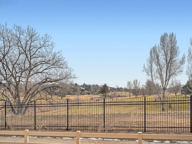 view of gate with a yard and a rural view