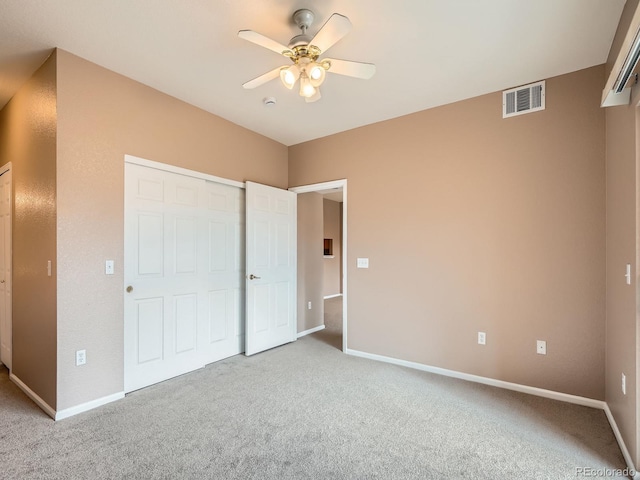 unfurnished bedroom featuring light carpet, ceiling fan, and a closet