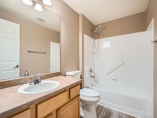 full bathroom with vanity, hardwood / wood-style flooring, toilet, and shower / bath combination