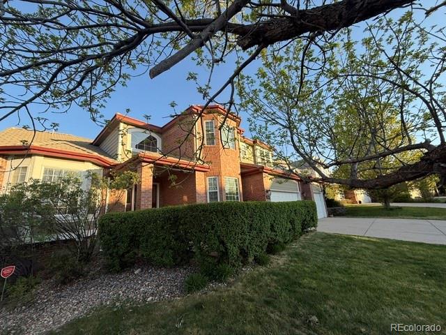 518 Zircon Way, Superior, CO 80027 - view of side of property with concrete driveway, brick siding, a yard, and an attached garage