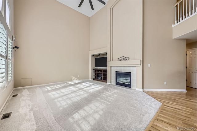 518 Zircon Way, Superior, CO 80027 - unfurnished living room with high vaulted ceiling, ceiling fan, wood finished floors, a tile fireplace, and baseboards