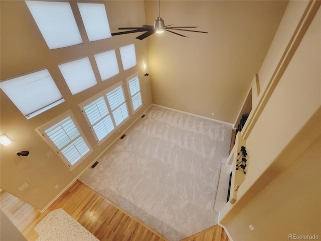 518 Zircon Way, Superior, CO 80027 - unfurnished living room with ceiling fan, a towering ceiling, wood finished floors, and baseboards