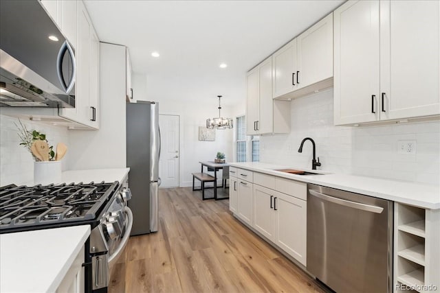 3413 W 114th Cir Unit B, Westminster, CO 80031 - kitchen with stainless steel appliances, light countertops, tasteful backsplash, white cabinets, and light wood-style floors