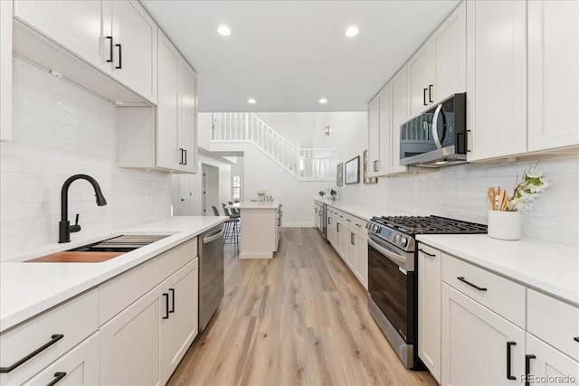 3413 W 114th Cir Unit B, Westminster, CO 80031 - kitchen with stainless steel appliances, tasteful backsplash, light wood-type flooring, light countertops, and recessed lighting