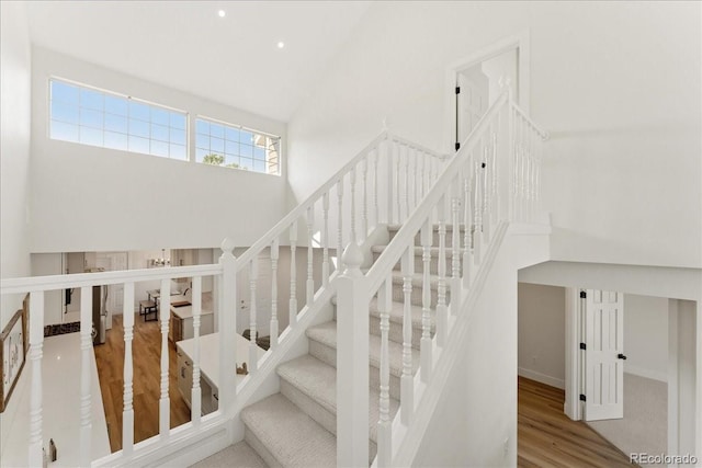3413 W 114th Cir Unit B, Westminster, CO 80031 - staircase featuring high vaulted ceiling, wood finished floors, and recessed lighting