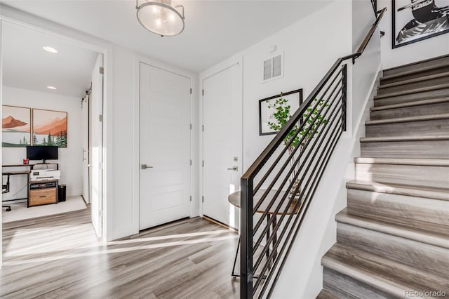 foyer with stairs, wood finished floors, visible vents, and recessed lighting