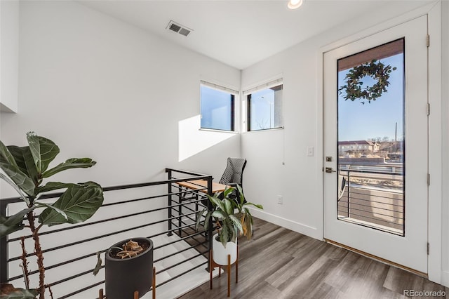 interior space featuring baseboards, visible vents, and wood finished floors