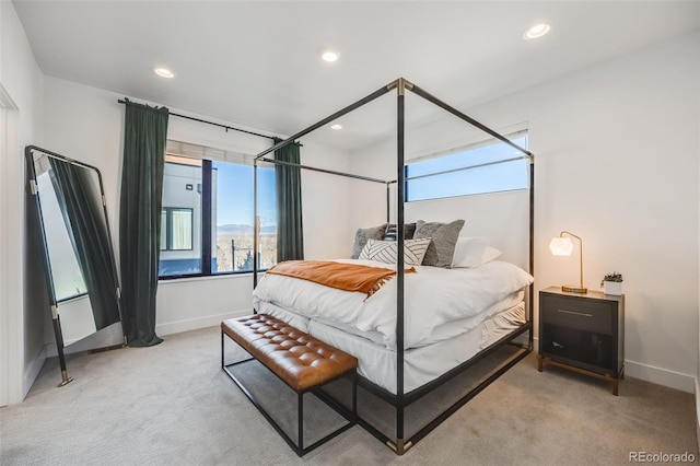 bedroom featuring light carpet, multiple windows, and baseboards