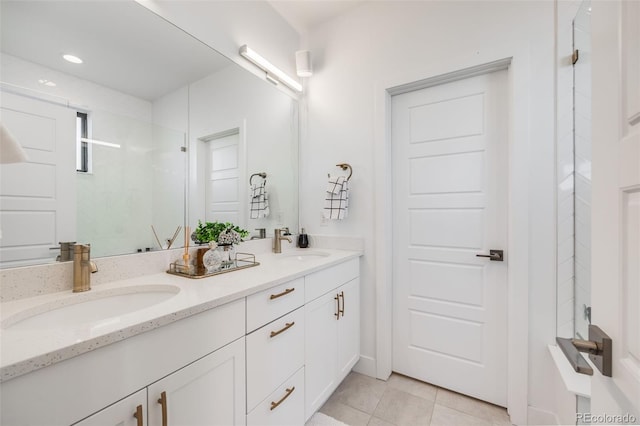 bathroom with double vanity, a shower, a sink, and tile patterned floors