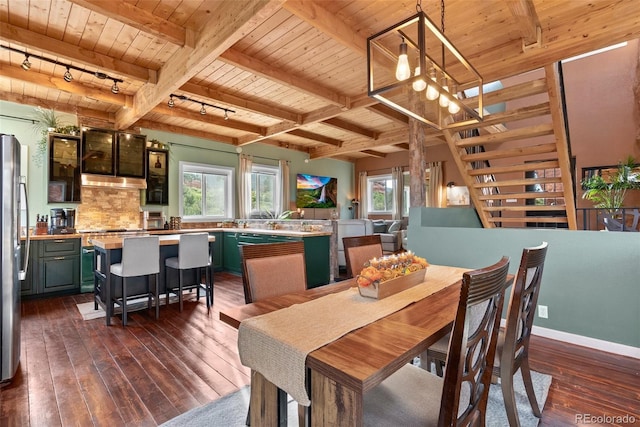 6619 Apache Pl, Larkspur, CO 80118 - dining area featuring wood ceiling with exposed beams, dark wood finished floors, healthy amount of natural light, rail lighting, and a chandelier