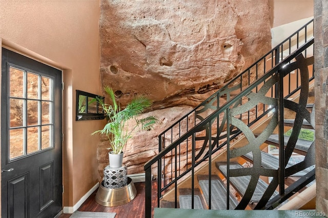 6619 Apache Pl, Larkspur, CO 80118 - staircase featuring wood finished floors, baseboards, and a towering ceiling