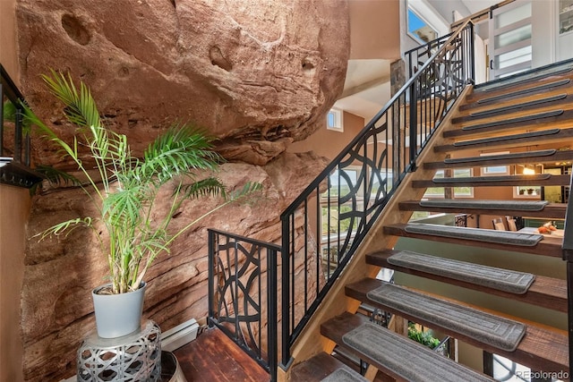 6619 Apache Pl, Larkspur, CO 80118 - staircase with a towering ceiling, baseboard heating, and wood finished floors