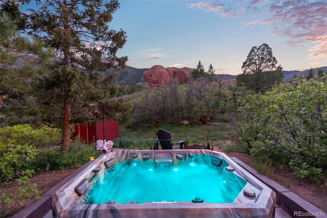 6619 Apache Pl, Larkspur, CO 80118 - pool at dusk featuring a jacuzzi and a mountain view