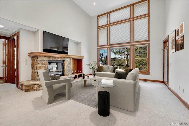 carpeted living room with a fireplace and a high ceiling