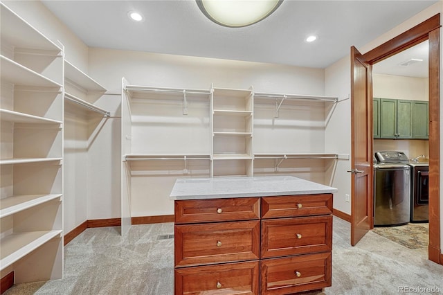 spacious closet with washer and dryer and light carpet