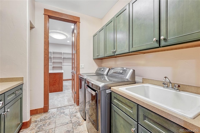 laundry area with cabinets, washer and clothes dryer, and sink