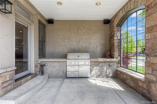 view of patio with area for grilling and a grill