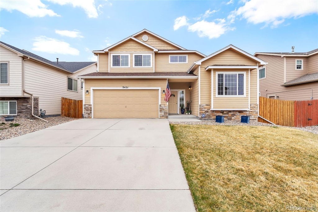 9451 Dakota Dunes Ln, Peyton, CO 80831 - craftsman-style home featuring concrete driveway, an attached garage, fence, and stone siding