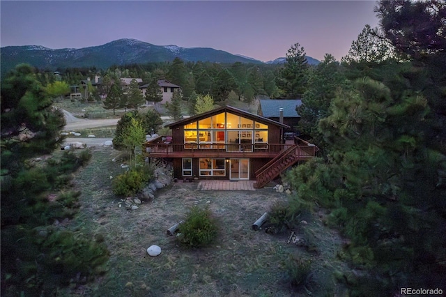 30455 Mountainside Dr, Buena Vista, CO 81211 - back of property at dusk featuring a deck with mountain view and stairs
