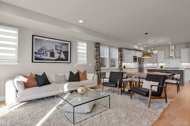 living room featuring sink and light hardwood / wood-style floors