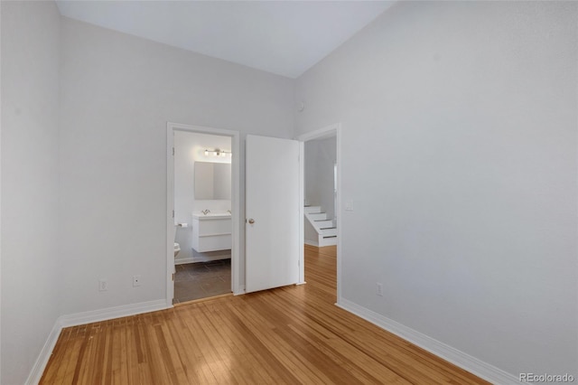 unfurnished bedroom with light hardwood / wood-style flooring and ensuite bath