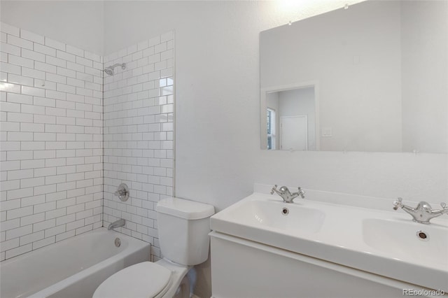 full bathroom with tiled shower / bath combo, toilet, and vanity