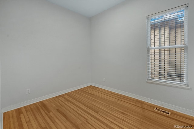 unfurnished room with hardwood / wood-style flooring