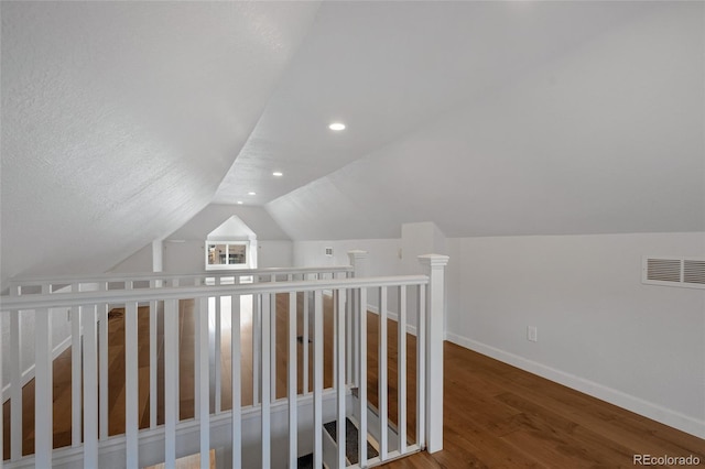 corridor featuring hardwood / wood-style flooring and vaulted ceiling