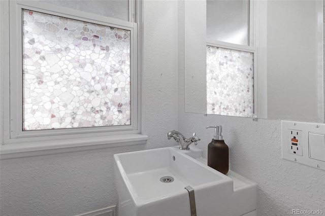 bathroom with a sink and a textured wall