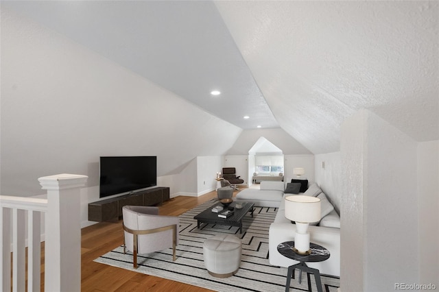 living area with wood finished floors, lofted ceiling, recessed lighting, and baseboards