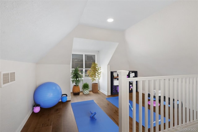 workout area featuring lofted ceiling, hardwood / wood-style floors, baseboards, and recessed lighting
