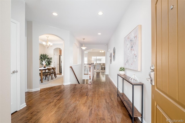 hall featuring hardwood / wood-style floors and a chandelier