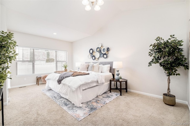 carpeted bedroom featuring a chandelier and vaulted ceiling