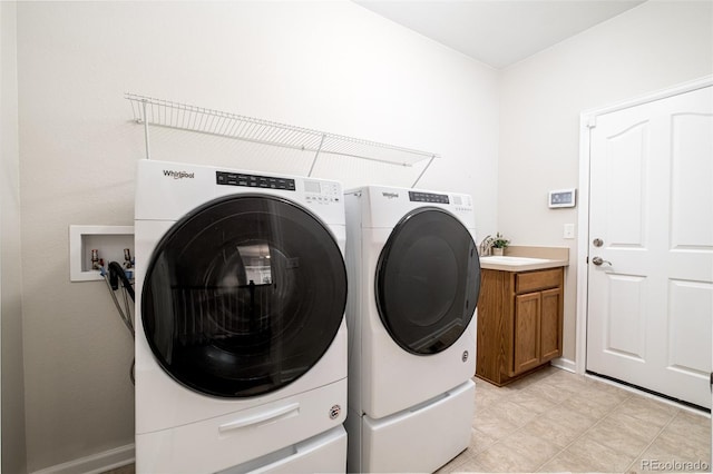 laundry room with cabinets, sink, and washing machine and clothes dryer