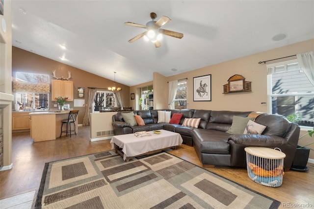 living room featuring ceiling fan with notable chandelier, light hardwood / wood-style floors, and lofted ceiling