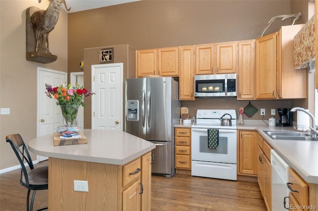 kitchen featuring sink, a center island, dark wood-type flooring, and appliances with stainless steel finishes