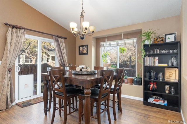 dining space featuring a wealth of natural light, hardwood / wood-style floors, and vaulted ceiling